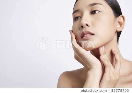 portrait of a beautiful woman with black hair touching her face 33778793