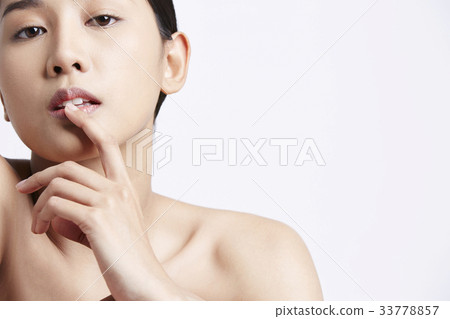 A young model is putting her finger on lips 33778857