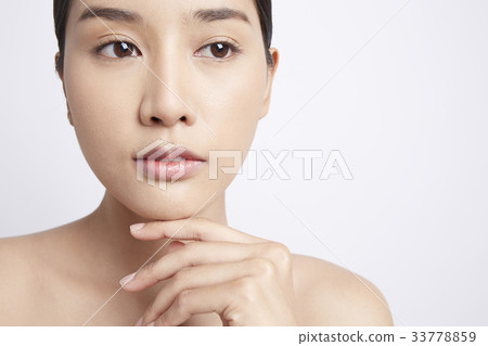 A young beautiful model is putting hand on chin and looking at something 33778859