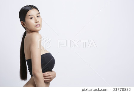 A beautiful model is standing and putting her hand on waist 33778883