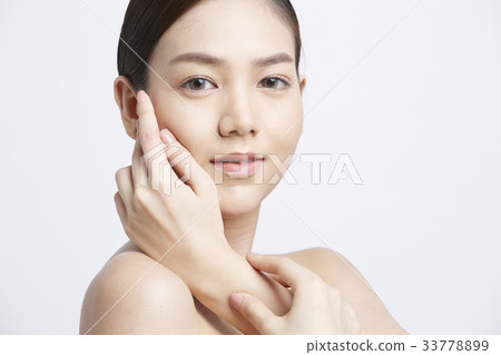 A young beautiful model is posing with hand on cheek 33778899
