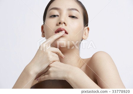 a girl is putting a finger on her lip 33778920