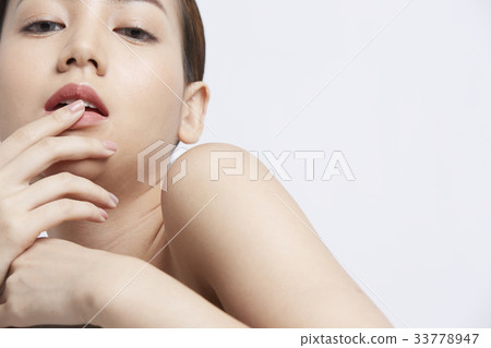 an attractive girl is putting fingers on her lip an attractive girl is putting fingers on her lip 33778947