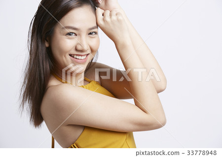 a girl is putting her hands on her hair and smiling 33778948