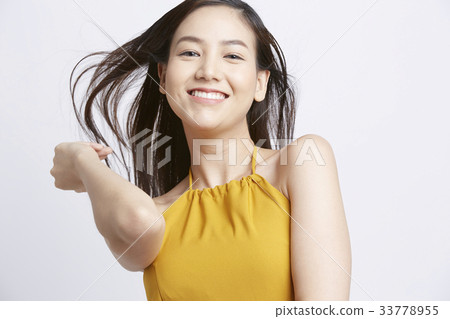 an attractive girl in yellow clothes is smiling and posing 33778955