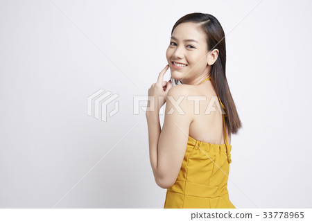 an attractive girl is looking at something and smiling 33778965