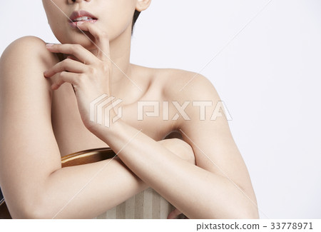 portrait of young woman posing with a finger on lips 33778971