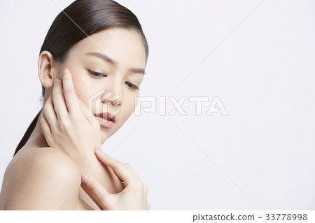 attractive girl is looking down with hand on her face on white background attractive girl is looking down with hand on her face on white background 33778998