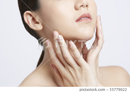 asian beautiful woman is applying moisturizer on her face asian beautiful woman is applying moisturizer on her face 33779022