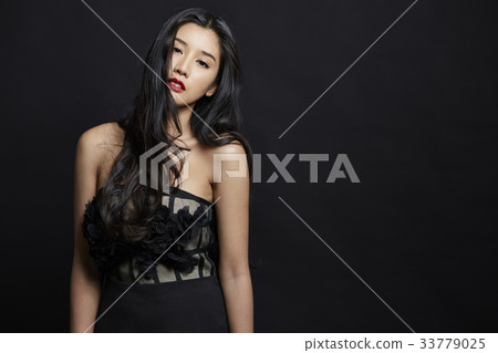 asian woman is standing and posing on black background 33779025
