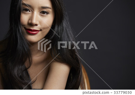 photo of smiling girl with a long curly hair on black background 33779030