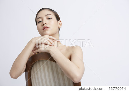 portrait of woman sitting on chair and looking at camera portrait of woman sitting on chair and looking at camera 33779054