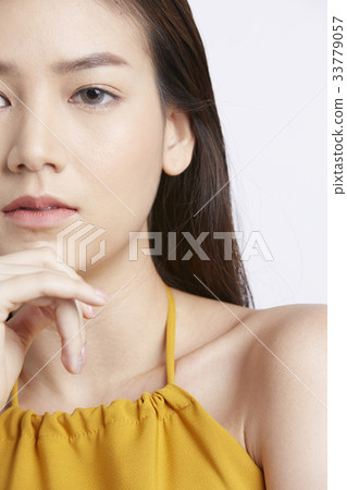 closeup portrait of young woman holding her chin 33779057