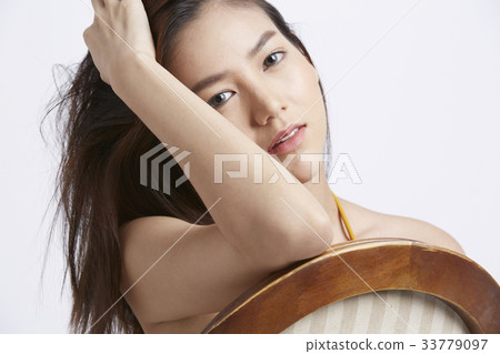 portrait of young woman touching her hair and thinking 33779097