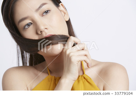 young woman is holding her hair and looking at something 33779104