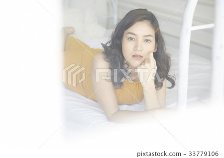 young beautiful woman is lying and looking at camera 33779106