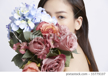 portrait of woman holding flower bouquet in studio 33779107
