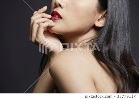 portrait of Asian girl touching her lip on black background portrait of Asian girl touching her lip on black background 33779117