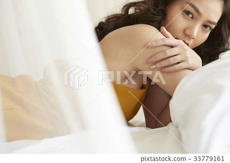 Portrait of beautiful young lady relaxing lying in bed 33779161