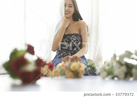 photo of a woman holding a curtain and smiling. 33779372