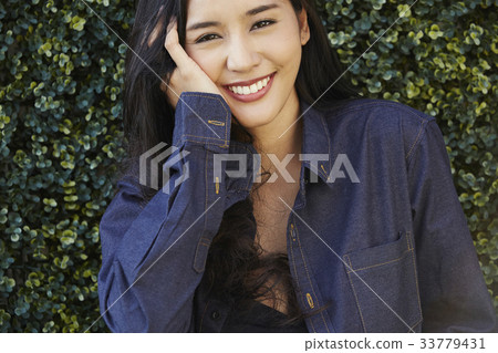 portrait of a girl standing outside and smiling 33779431