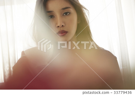 portrait of a girl holding a cup and staring at camera 33779436