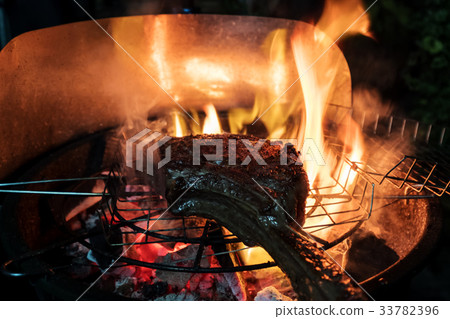Tomahawk beef steak on grilled roaster with flames 33782396