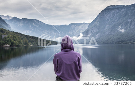 Woman wearing purple hoodie watching tranquil 33787205