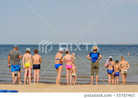 People standing on sand near sea People standing on sand near sea 33787463