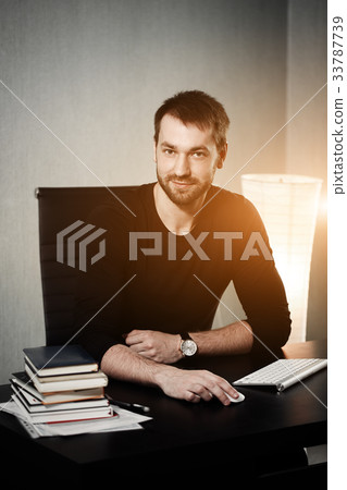 Smart businessman at workplace in office holding Smart businessman at workplace in office holding 33787739