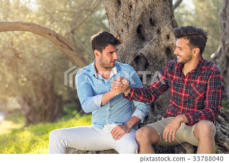 圖庫照片: happy gay couple hugging in park