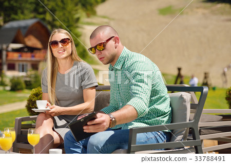 Young couple drinking coffee in their garden on a 33788491