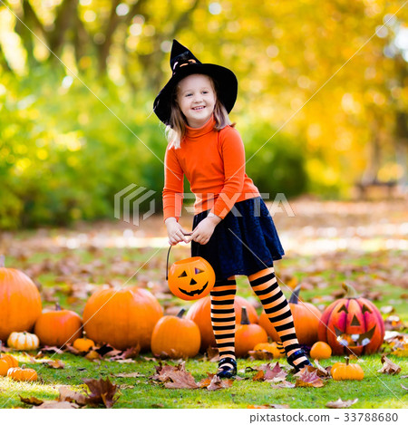 Girl in witch costume on Halloween trick or treat 33788680