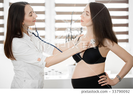 female medicine doctor holding stethoscope to female medicine doctor holding stethoscope to 33790092