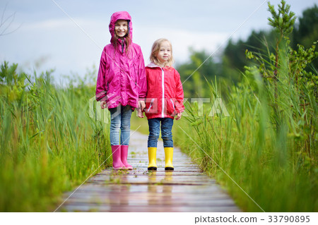 Two funny little sisters having fun during forest hike Two funny little sisters having fun during forest hike 33790895
