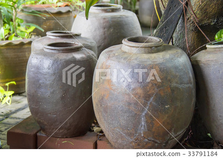 Black clay jar many sizes in a tree shade. Black clay jar many sizes in a tree shade. 33791184