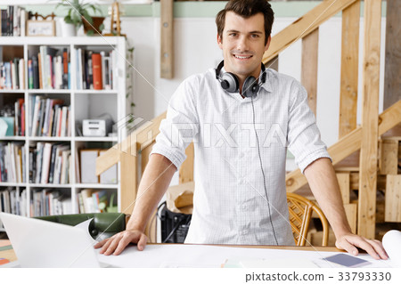 Young man standing in creative office Young man standing in creative office 33793330
