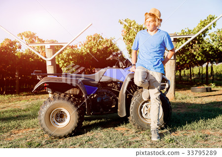 Boy standing next to truck in vineyard Boy standing next to truck in vineyard 33795289