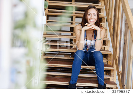 Portrait of young woman sitting at the stairs in office Portrait of young woman sitting at the stairs in office 33796887