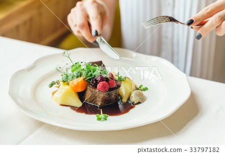 women eating beef steak with berry sauce women eating beef steak with berry sauce 33797182