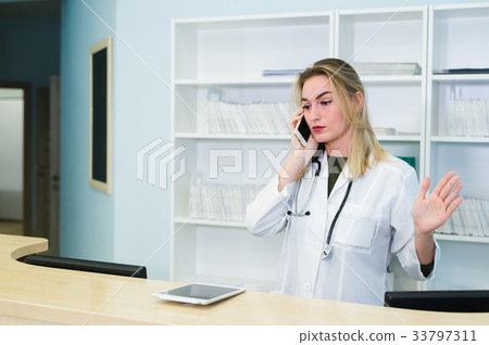 Smiling female doctor wearing a scrub and working 33797311