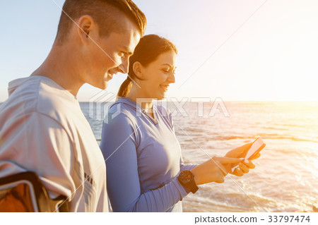 Young couple with smartphones outdoors Young couple with smartphones outdoors 33797474