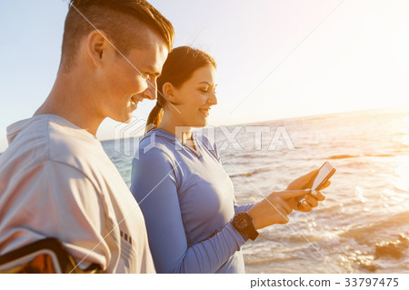 Young couple with smartphones outdoors Young couple with smartphones outdoors 33797475