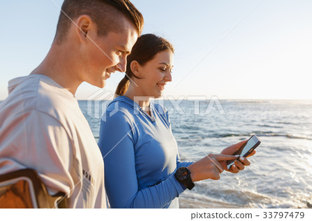 Young couple with smartphones outdoors Young couple with smartphones outdoors 33797479