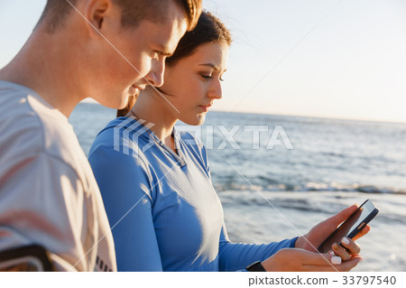 Young couple with smartphones outdoors Young couple with smartphones outdoors 33797540