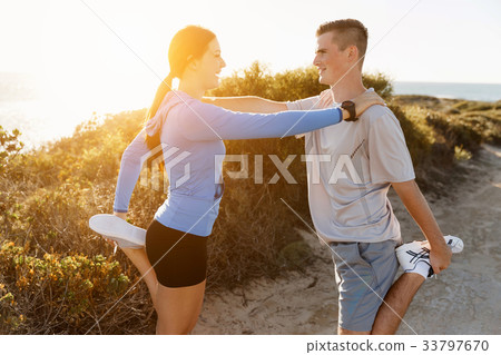 Young couple on beach training together 33797670