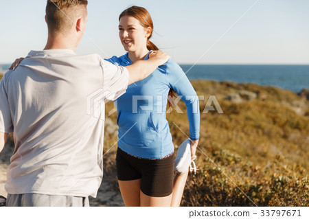 Young couple on beach training together 33797671