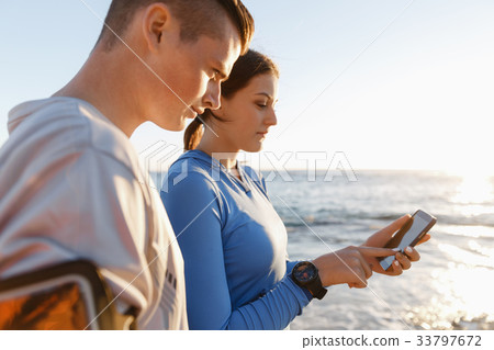 Young couple with smartphones outdoors 33797672