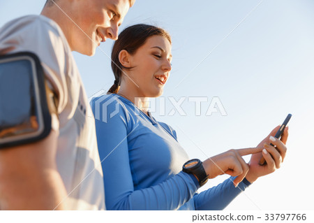 Young couple with smartphones outdoors Young couple with smartphones outdoors 33797766