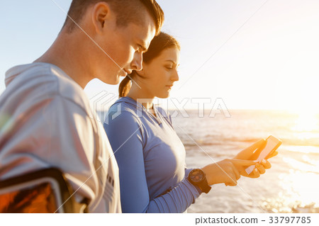 Young couple with smartphones outdoors 33797785